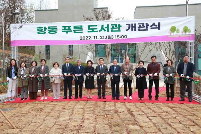 문헌일 구청장(오른쪽에서 일곱번째)과 주요 참석자들이 21일 열린 항동 푸른 도서관 개관식에서 테이프 커팅을 하고 있다.