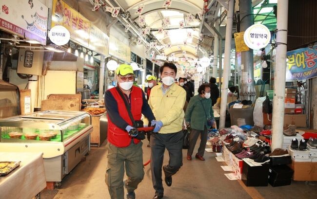 소방호스를 들고 발화지점으로 뛰고있는 박준희 구청장과 자율소방대원