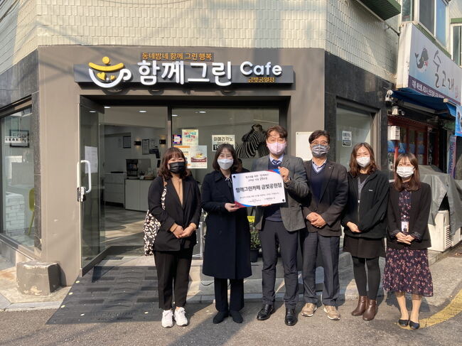 함께그린카페 금빛공원점 앞에서 금천시니어클럽과 서울시립청소년이동쉼터 관계자 등이 기념촬영을 하고 있다