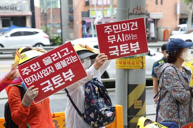 어명소 국토교통부 제2차관은 1월 27일 15시 광명서울고속도로 건설현장을 찾아 공사 진행상황을 점검하고 관계자들을 격려했다. 사진은 지난 2019년 5월30일 광명서울고속도로 온수터널 구간의 주민들이 학교 밑 발파, 수직구 강행 등 해당 공사의 문제점을 지적하며 국토부에 항의하는 모습이다.&nbsp;