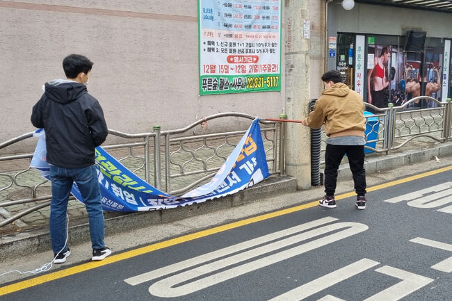 7일 불법 현수막을 철거하고 있는 신길7동 주민센터 직원들(사진=영등포구청 제공)