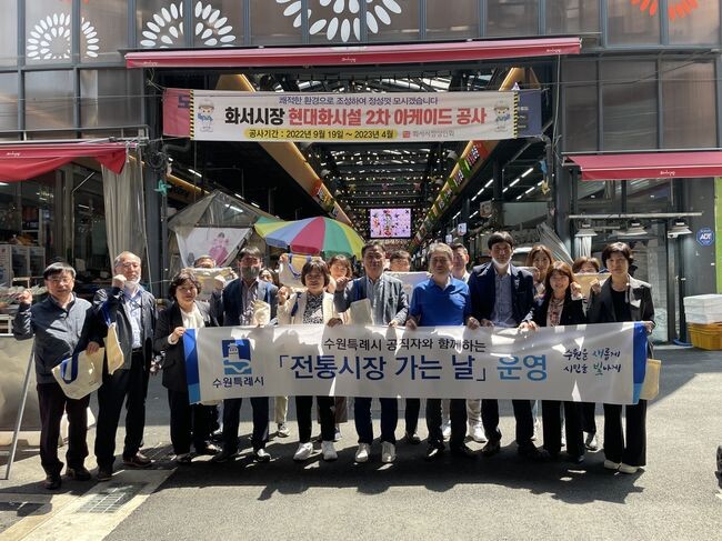 &lsquo;전통시장 가는 날&rsquo; 행사에 참여한 경제정책국 직원들이 화서시장에서 함께하고 있다.&nbsp;