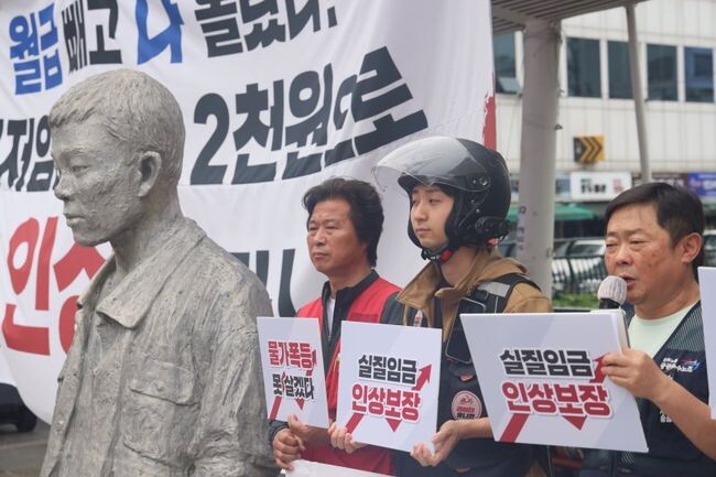 민주노총 공공운수노조 소속 조합원들이 18일 오전 서울 종로구 전태일다리에서 최저임금 투쟁선포 기자회견을 하고 있다.&nbsp;