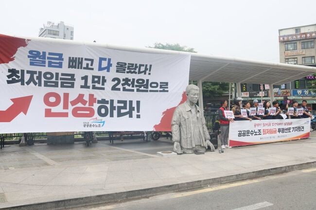 <span contenteditable="true">민주노총 공공운수노조 소속 조합원들이 18일 오전 서울 종로구 전태일다리에서 최저임금 투쟁선포 기자회견을 하고 있다.&nbsp;