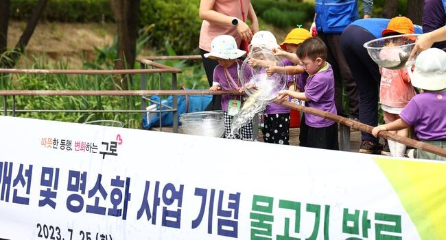 어린이들이 물고기를 방류하고 있다.
