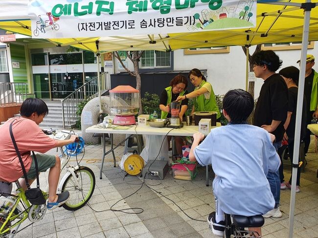 에너지축제에서 솜사탕 만들기 체험을 하고 있는 주민들