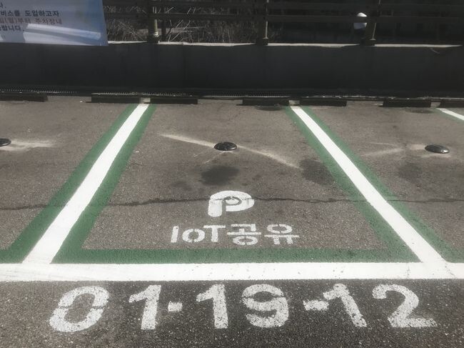 주차장 바닥에 무선차량감지센서가 부착되어 있는 모습