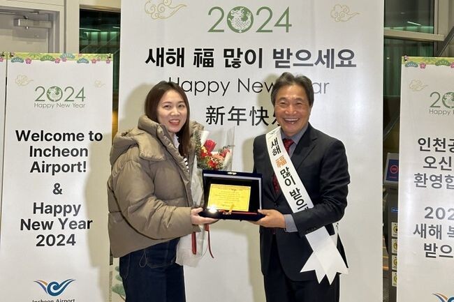 인천공항 제2여객터미널에서 열린 환영행사에서 이학재 사장(우측)이 새해 첫 여객(쫑위에, 중국 국적)에게 황금 기념패를 전달하고 있다.