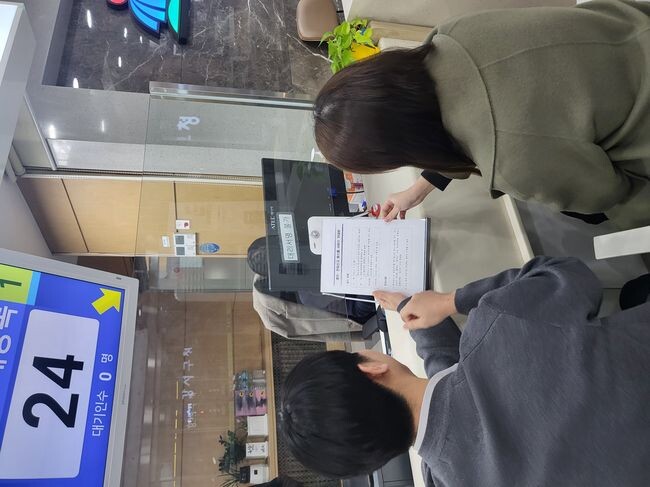 혼인, 전입신고 원스톱 서비스 안내문을 읽고 있는 신혼부부 
