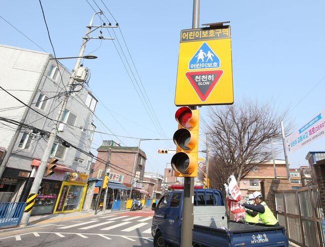불법광고물 정비반이 초등학교 주변 불법현수막을 정비하고 있다(제공=용산구)