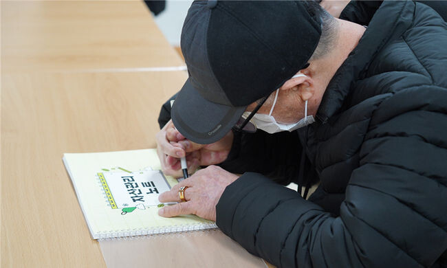 인천장애인주거전환센터와 미추홀장애인복지관, 인천장애인자립생활센터가 함께 진행하는 장애인 자립지원 프로그램 참가자가 &lsquo;자산관리노트&rsquo;에 이름을 쓰고 있다.
