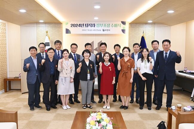 퇴직공무원 15명과 조용익 부천시장이 정부포상 수여식에서 기념사진을 촬영하고 있다.