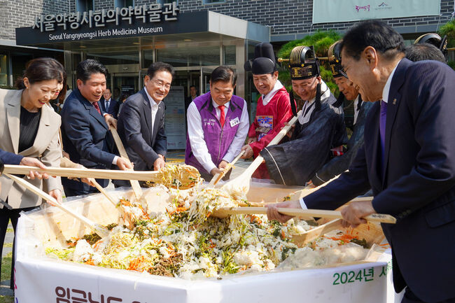 이필형 동대문구청장(보라색 조끼)을 비롯한 한방산업 특화 자치단체장 및 관계자들이 &lsquo;한방산채비빔밥 퍼포먼스&rsquo;를 선보이고 있다.