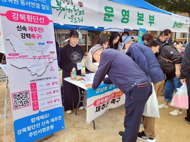 19일 성북구 종암동에서 진행된 ‘종암동 북바위 청포도 문화제’ 현장에 마련된 ‘강북횡단선 신속 재추진 성북구민 서명운동’ 에 동참하고 있는 성북구민들