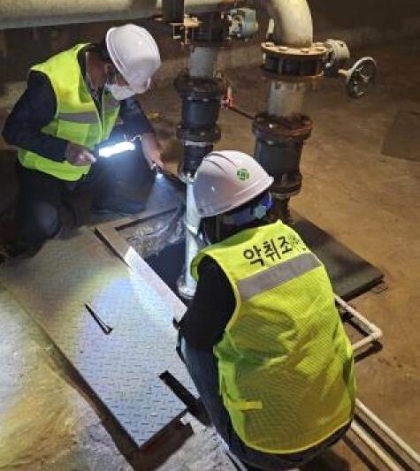 정화조에 설치된 악취 저감시설을 점검하고 있는 모습