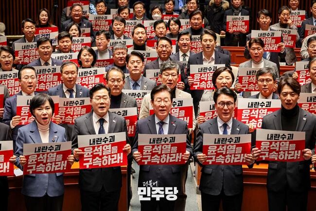 이재명 당대표와 박찬대 원내대표가 2024.12.23.(월) 국회 본청 예결위회의장에서 열린 더불어민주당 의원총회에 참석하여 피켓을 들고 구호를 외치고 있다.