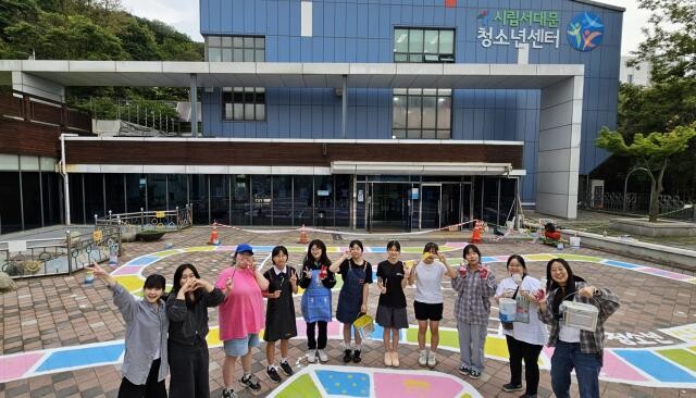 서대문청소년센터 청소년운영위원회 `꿀비`의 청소년 위원들이 센터 앞마당 바닥화 개선 작업을 완료한 후 기념사진을 촬영하고 있다
